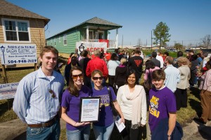 ASLA的学生穿着紫色的大便帮助重建新奥尔良的第九区;房子在后台